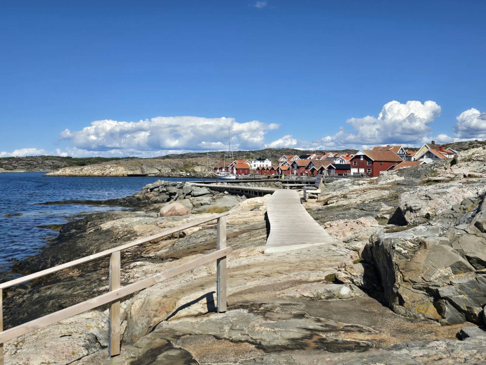 Träspång över klippor mot ett fiskeläge på Orust
